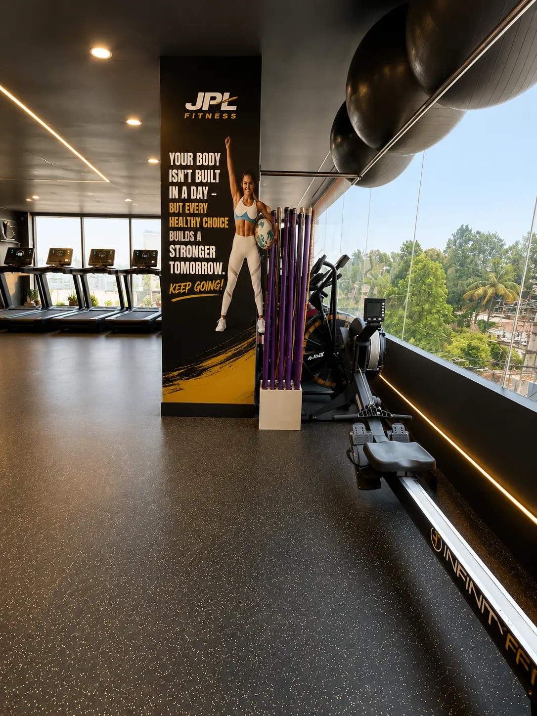 Rowing machine and treadmills beside daylight windows